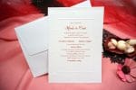 un plic alb cu invitatie cu text roșu pe ea